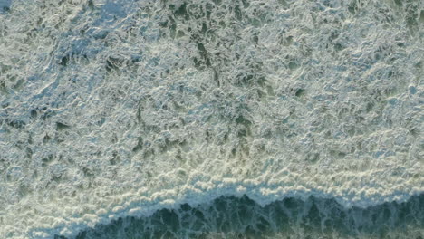 Olas-De-Espuma-Blanca-Que-Se-Estrellan-En-La-Hermosa-Luz-De-La-Tarde,-Vista-Aérea-De-Pájaros,-Estática