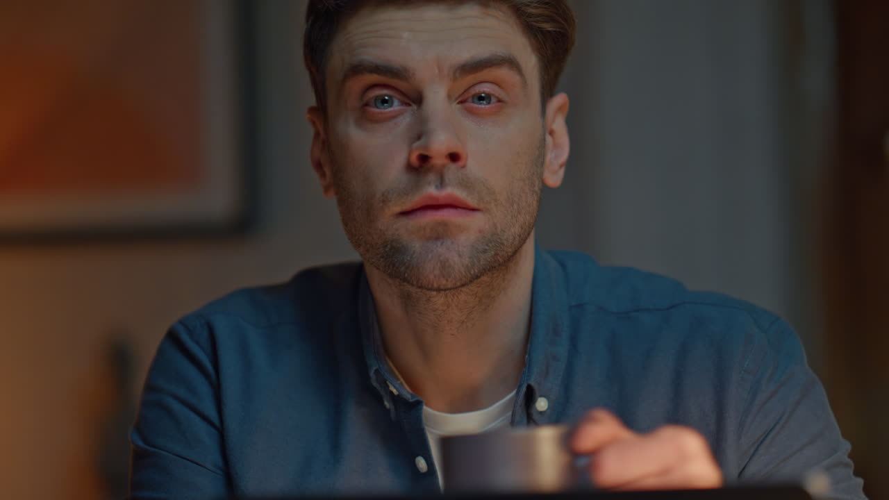 Late worker watching computer screen at night flat closeup. Man looking distance