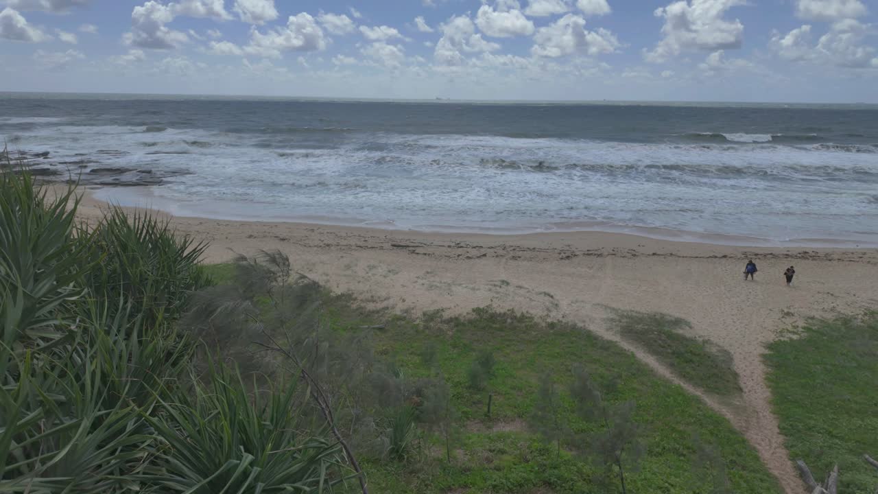 4K video of a sandy beach with large crushing waves on a windy day in Australia