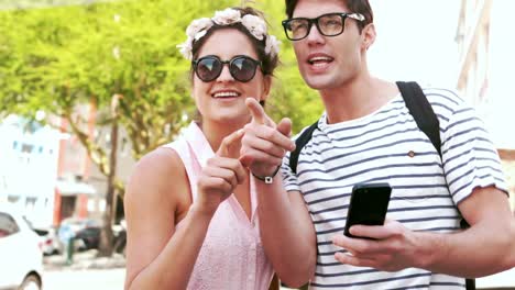 Smiling-hipster-couple-pointing-direction