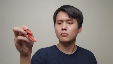 young chinese man holding chopsticks. close-up shot