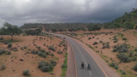drone takes an aerial shot of the highway in tharparkar located in sindh where two biker are driving their bike