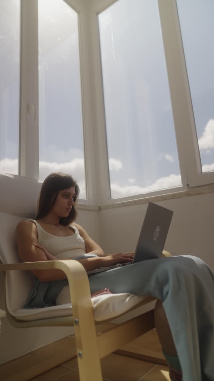 mujer trabajando en una computadora portátil en un balcón