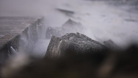 Aufnahme-Mit-Flachem-Fokus-über-Dem-Wellenbrecher,-Während-Stürmische-Winde-Gischt-Und-Gischt-In-Die-Luft-Blasen