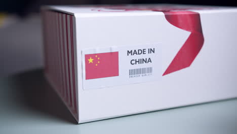 hands applying made in china flag label on a shipping cardboard box with products