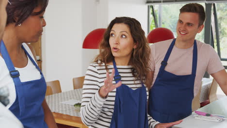 estudiantes adultos de sexo masculino y femenino que participan en una clase de cocina en la cocina