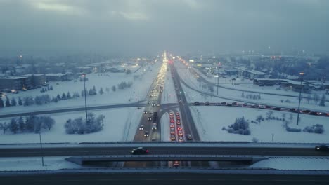 drone shot of freeway or highway traffic during rush hour on a foggy and winter evening, shot straight down the freeway as cars pass along