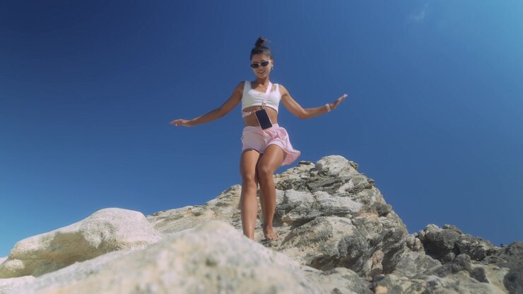 Giovane donna in equilibrio su una scogliera rocciosa