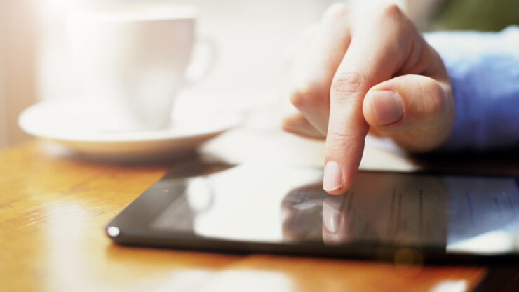 uomo d'affari che usa il touchscreen del tablet in un caffè