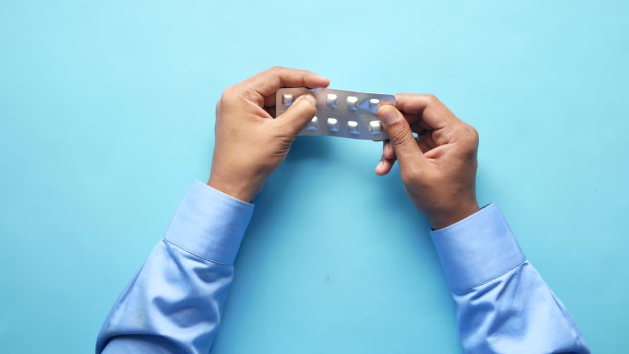 persona que abre un blister de pastillas