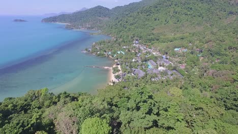 aerial shot of jungle, beach, ocean and resort hotel on a tropical island