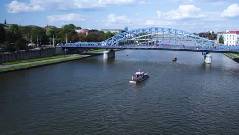 Aerial-view-of-boats-cruising-on-Vistula-River-in-Krakow-City-during-sunny-day,4K