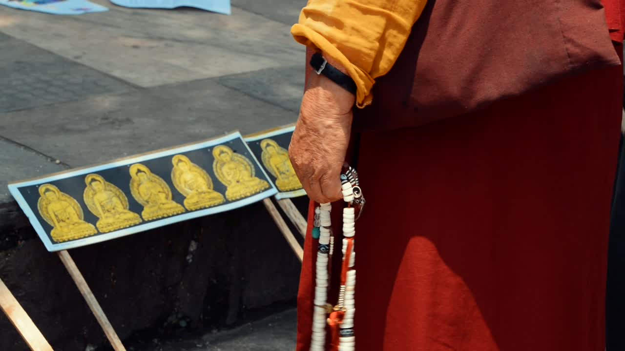 Buddhist monk praying with the prayer beads