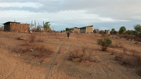 Man-From-Karo-Tribe-Walking-Home-With-Herd-Of-Goats-In-Omo-Valley,-Ethiopia