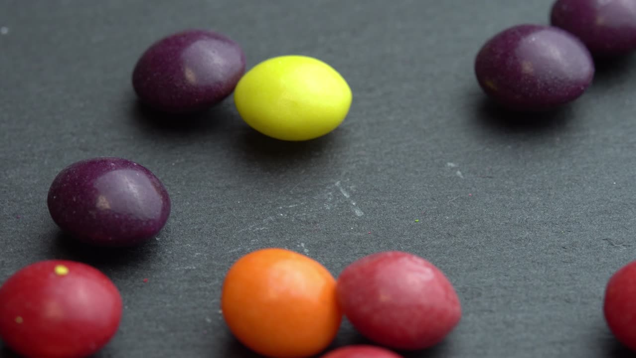 dulces de frutas de colores esparcidos sobre un fondo negro, dulces de marco de colores