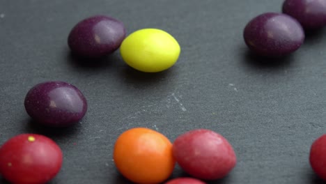 colored fruit sweets scatter on a black background, colored marco sweets