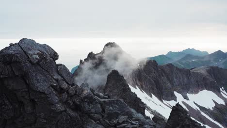 picos de pináculo con nubes de niebla en kvaenan, isla de senja, noruega