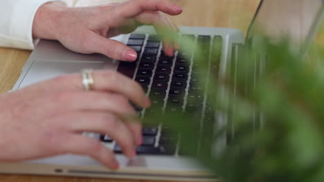 una mujer escribiendo en una computadora portátil