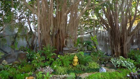 buddha statue sitting under a tree surrounded by vegetation at white temple, thailand.