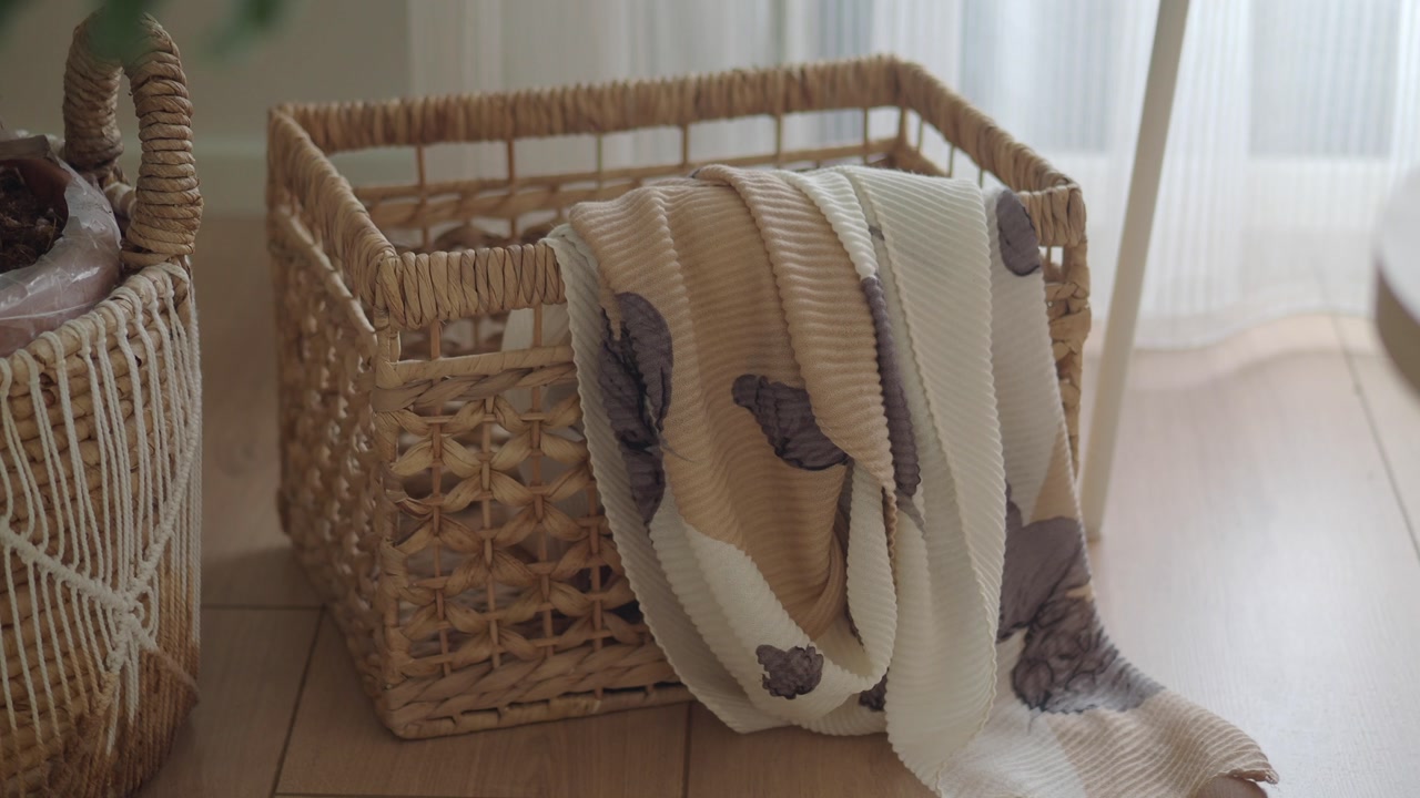 Cozy Pleated Blanket Draped Over a Woven Basket on Wooden Floor