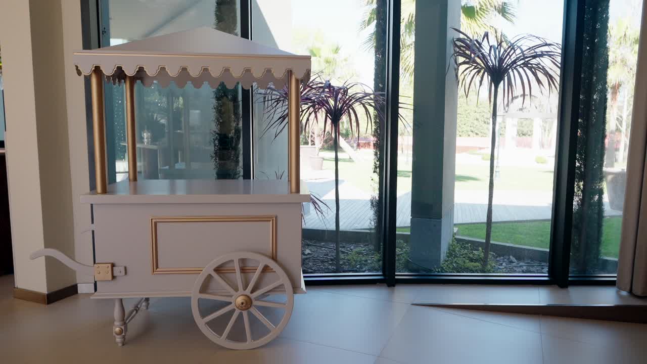 Dessert cart in a modern venue with large windows and garden view