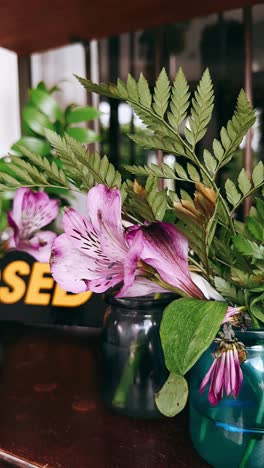 purple flowers and ferns in vases