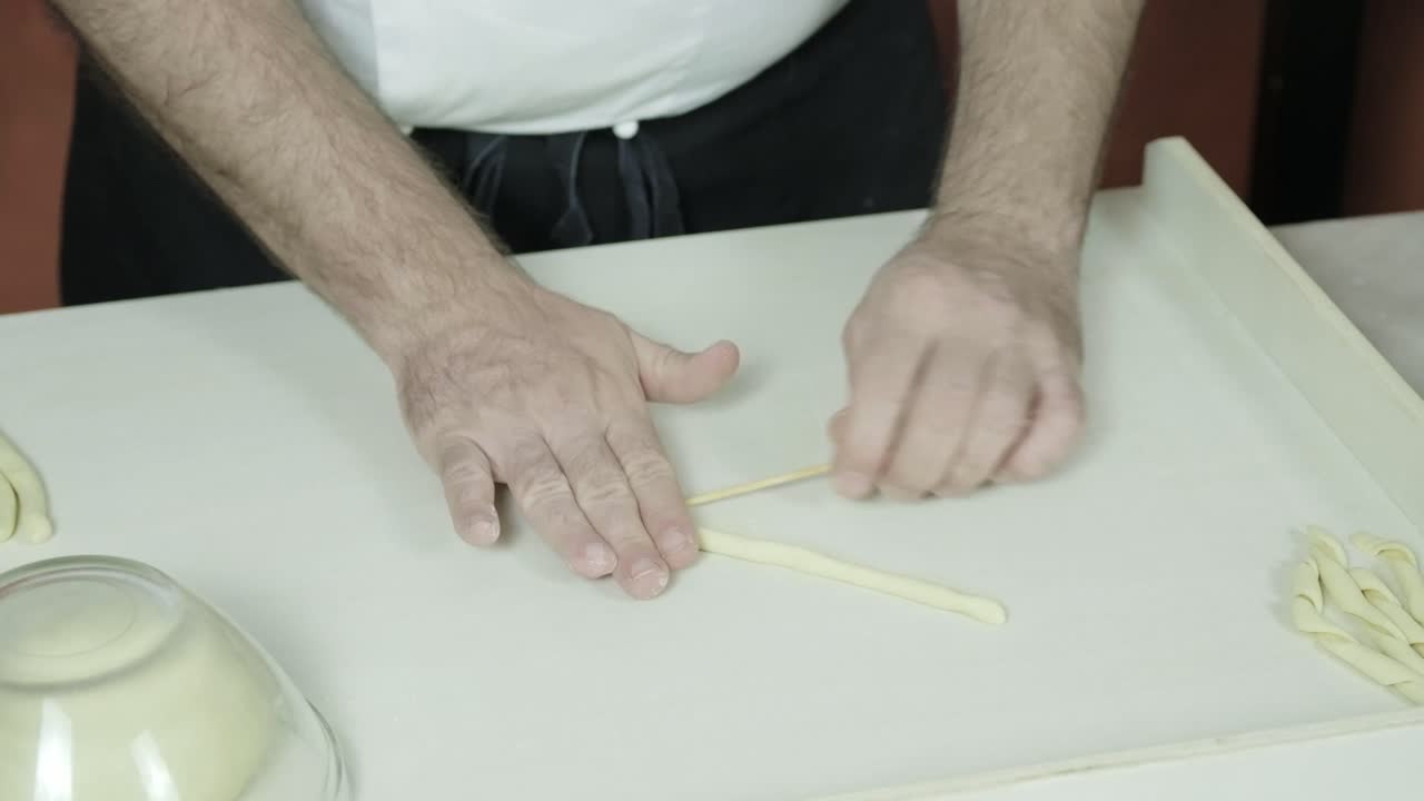 close up hands chef preparing traditional hand made italian pasta called Busiate