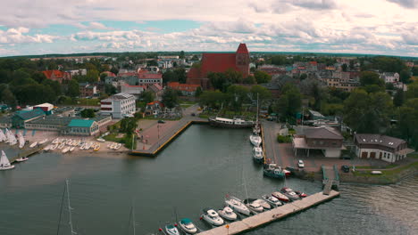 luftaufnahme einer drohne, die von der bucht in die stadt puck fliegt, mit wolken im hintergrund