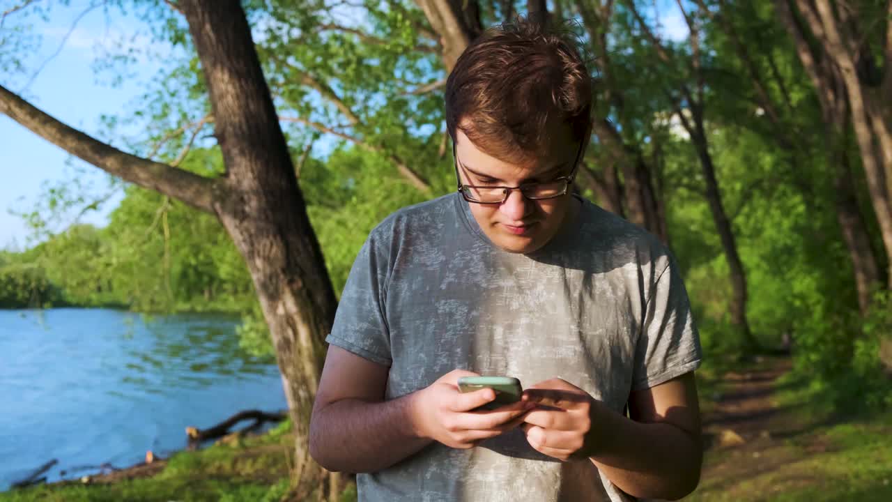 강변의 공원에서 스마트폰을 사용하는 십대