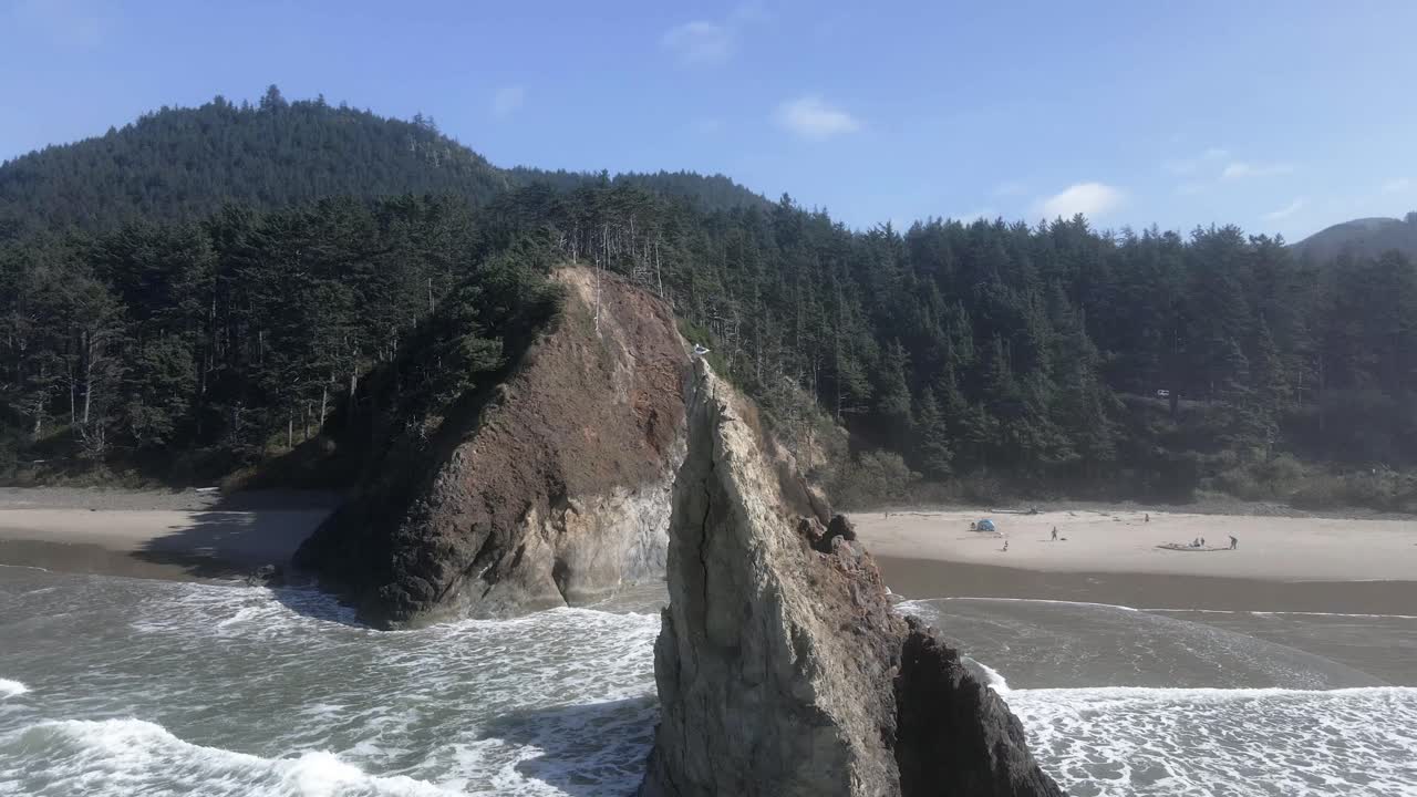 Un gabbiano solitario si posa sulla cima di una grande formazione rocciosa naturale, Lion Rock, Arcadia Beach, ripresa aerea orbitante