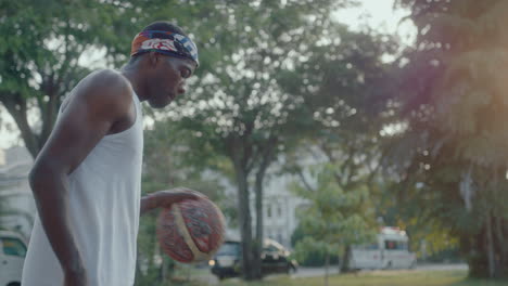 young black basketball player dribbling ball on outdoor court