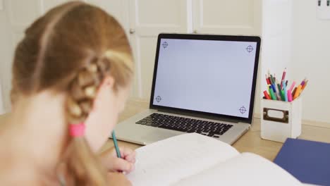 Caucasian-girl-having-a-video-call-on-laptop-with-copy-space-while-doing-homework-at-home