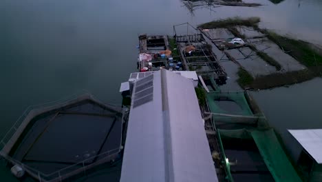 floating fish farms on a lake at sunset