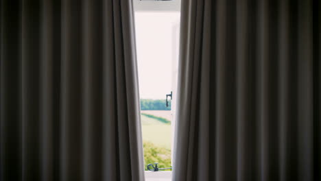 Bedroom-Curtains-Open-To-Reveal-Countryside-Through-Window