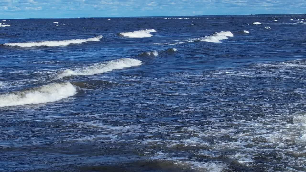 Waves roll and crash on the shore of the Baltic Sea on a sunny day