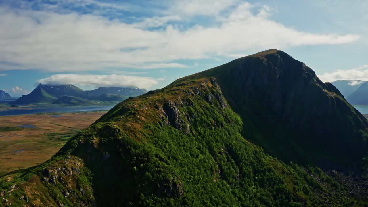 Aerial drone the over the picturesque landscape of the Lofoten Islands in Norway. High view of the green mountains, vast landscape and the blue Norwegian sea. Breathtaking nordic landmark.