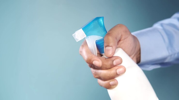 Person spraying cleaning product