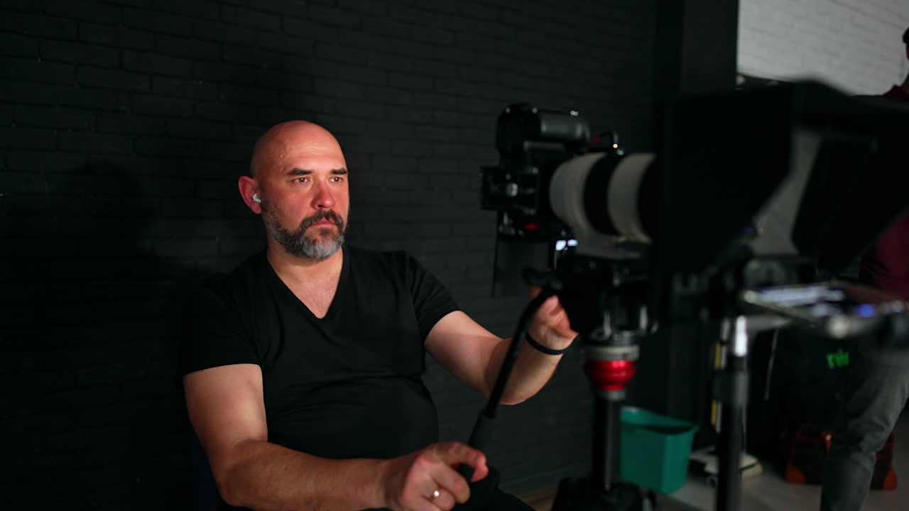 Caucasian cameraman uses professional equipment for footage. Video content creation. Backstage in studio.