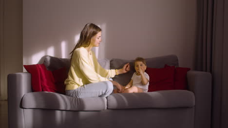 front view of woman and her baby sitting on sofa at home