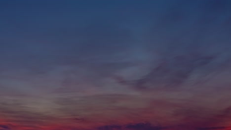 sky colored from blue to red with clouds advancing in a timelapse