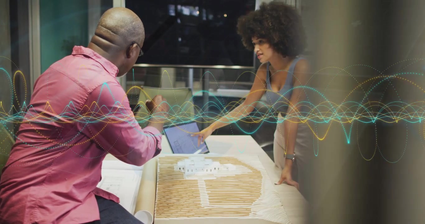 Woman placing laptop leaning over model man pointing and checking waveform overlay guiding planning