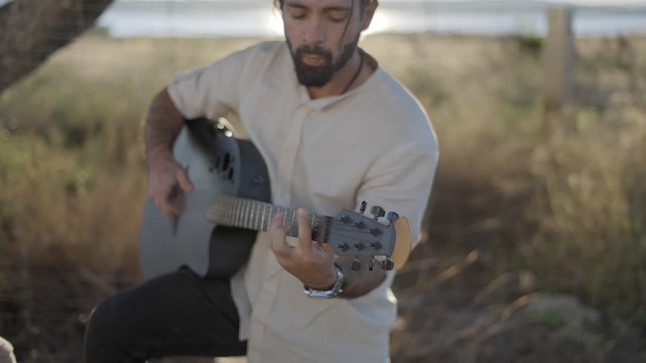 hombre tocando la guitarra acústica al aire libre