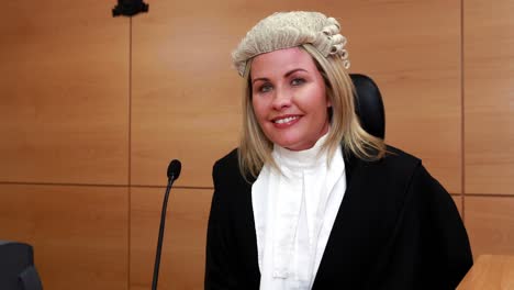 portrait of a smiling judge wearing robes and wig