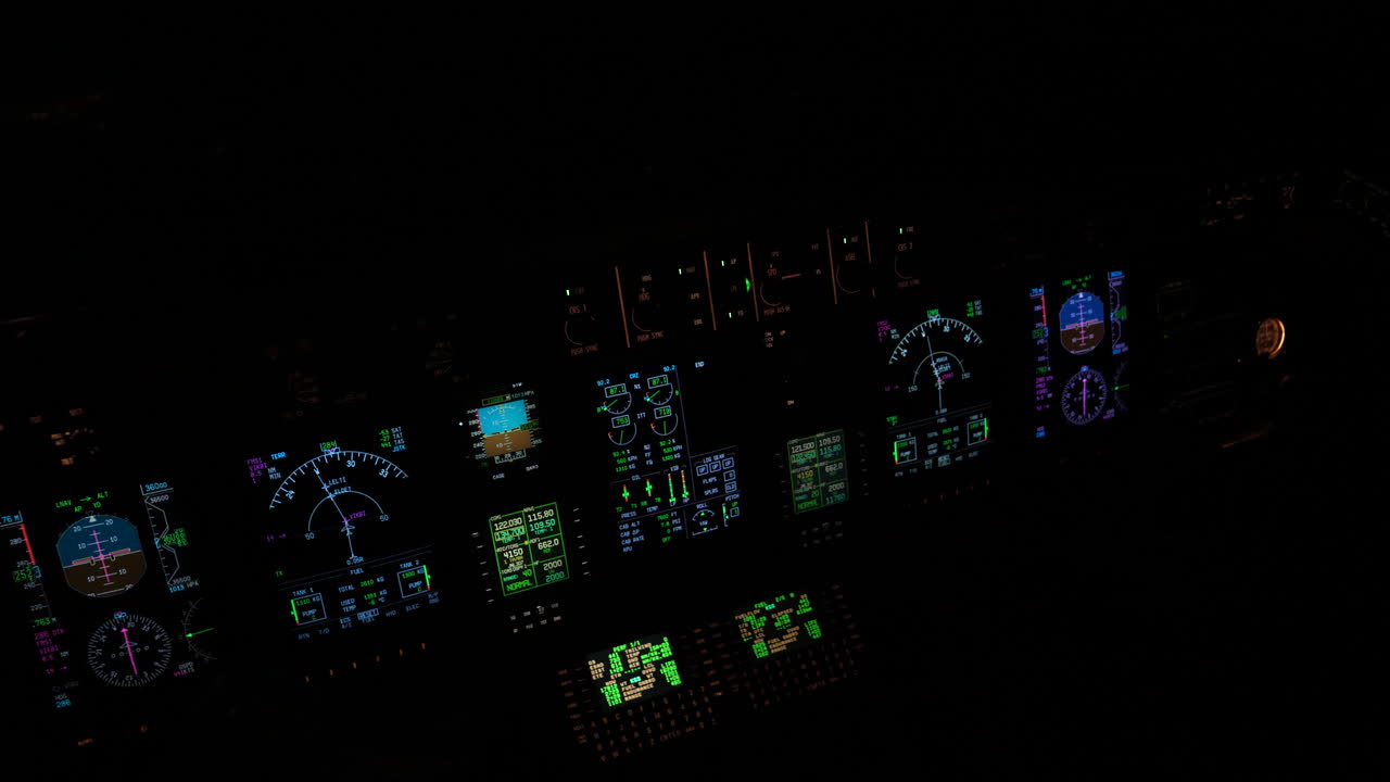 instrumentos iluminados y aviónica de la cubierta de vuelo de un avión en una cabina negra