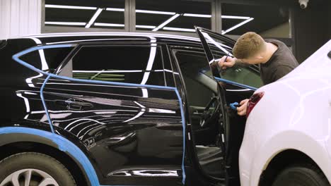 man covering car with vinyl polyurethane tape. films for the car. sticker protective film on the car