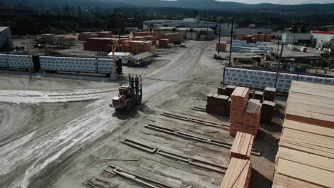 Forklift-driving-in-sawmill-lumber-yard-aerial-Drone