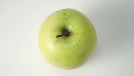 manzana verde madura en un primer plano de fondo blanco.