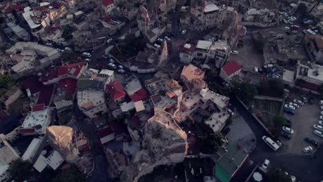 Drone-pans-down-from-sunrise-balloons-to-Göreme-cityscape