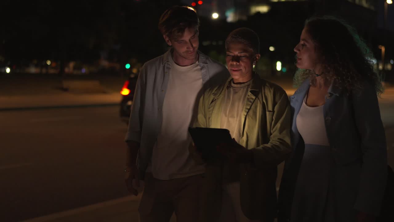 People using tablet at night in the city