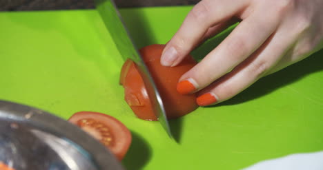 slicing tomato in kitchen